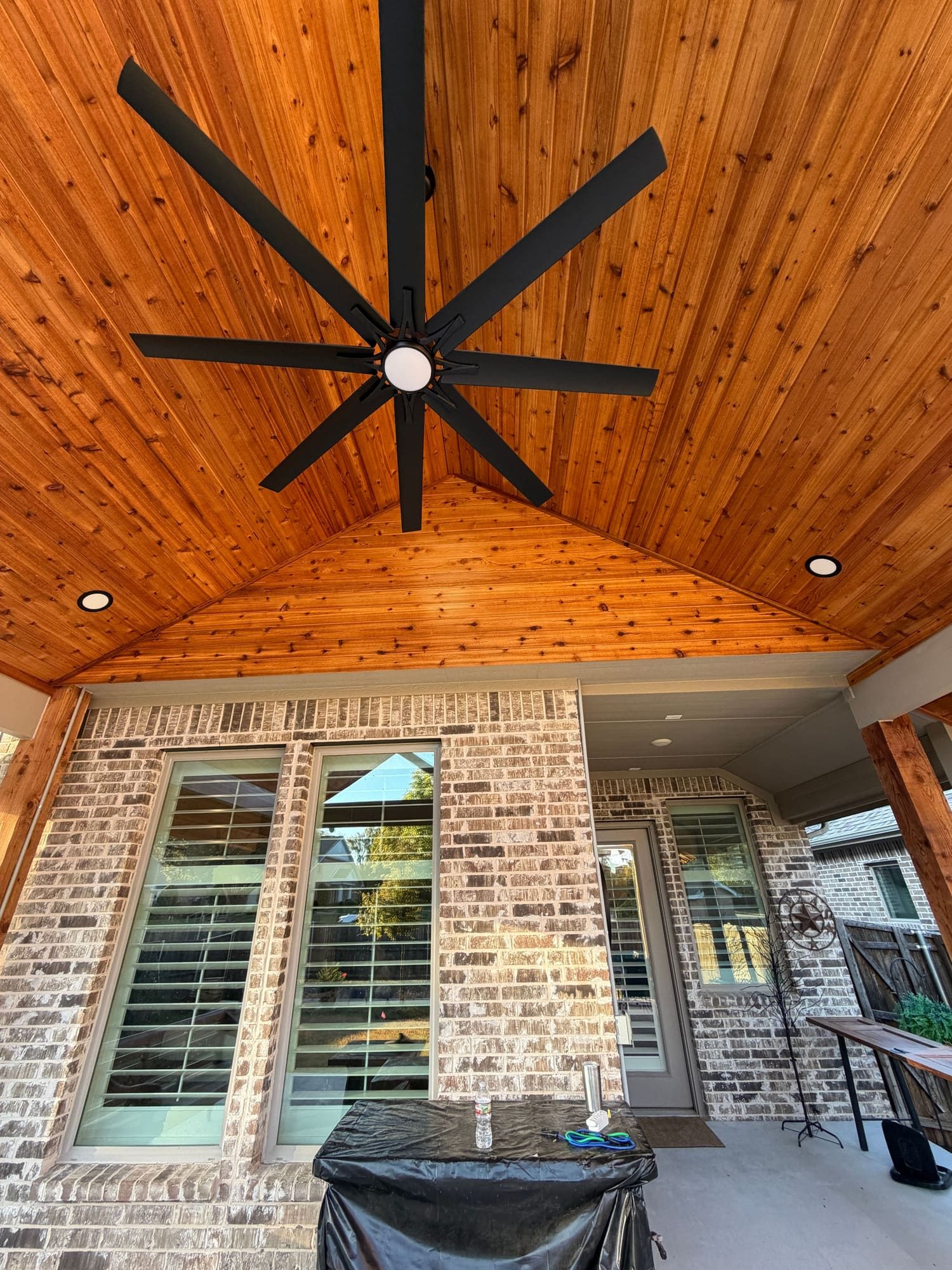 Tongue-and-groove wood ceiling and fan inside a gable patio cover in McKinney, Texas