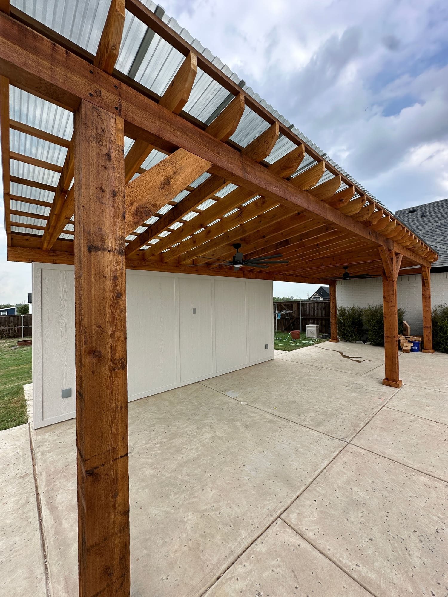 Cedar patio cover with polycarbonate roof and ceiling fans in Fort Worth, Texas
