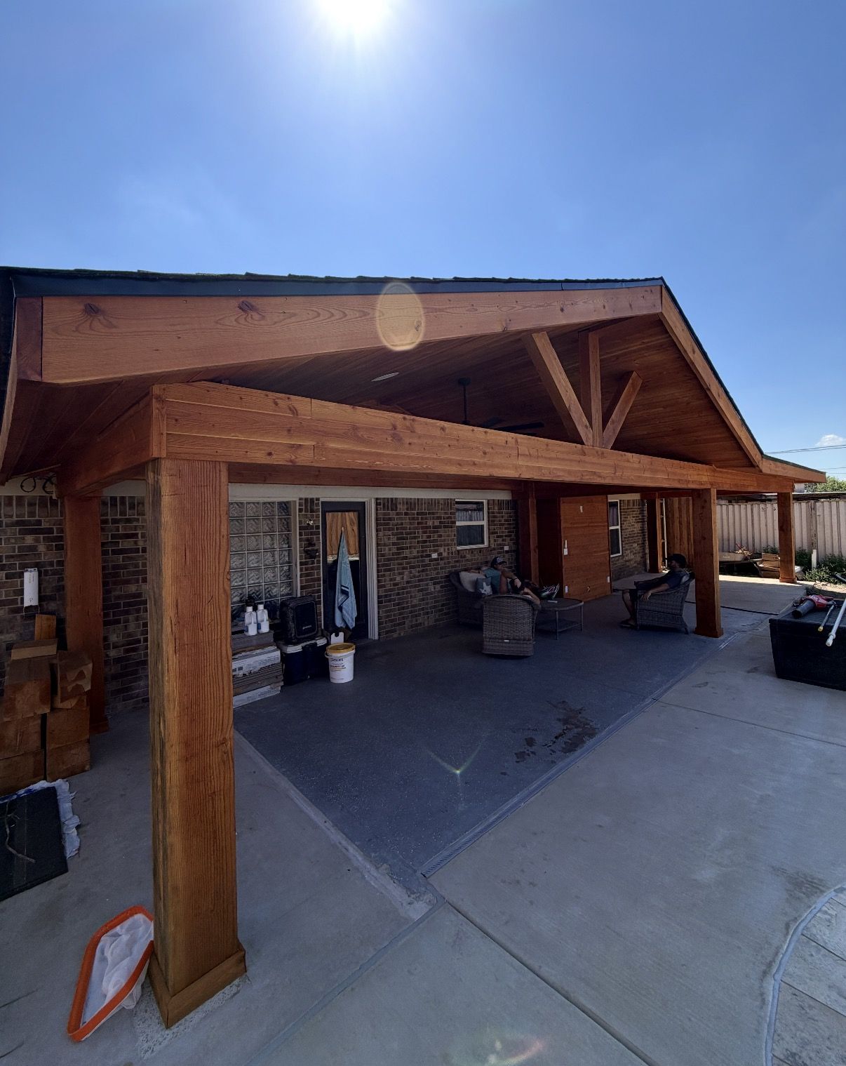 Gable patio cover with cedar posts and trusses over a new concrete patio in Watauga, Texas