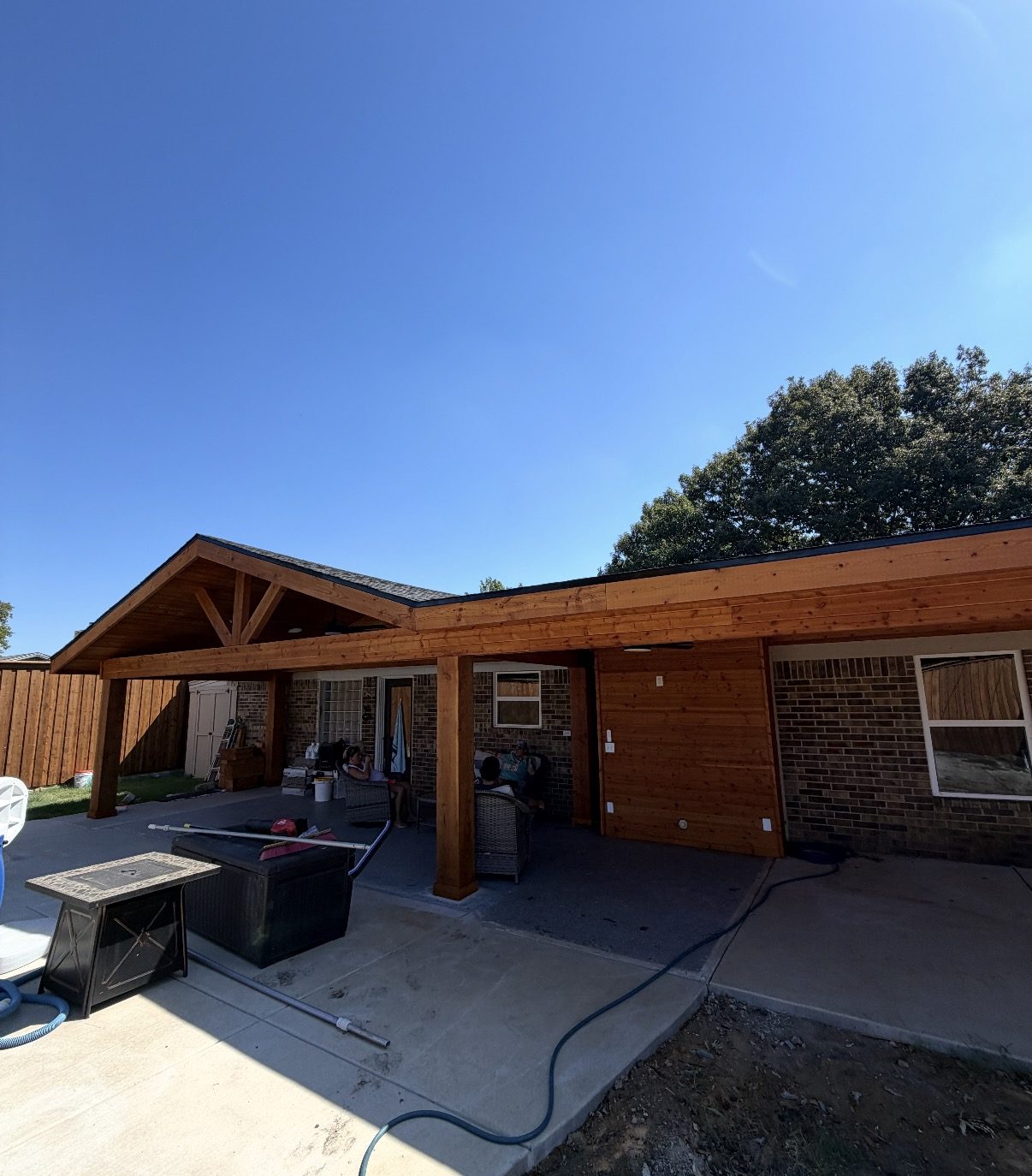 Cedar gable home extension with a shed-roof wing along the back of a brick home in Watauga, Texas